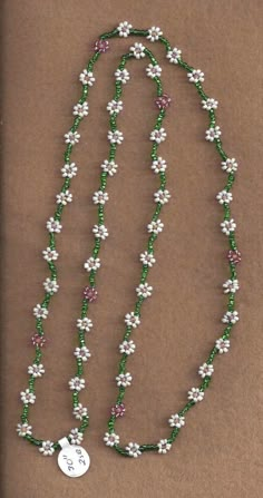 a green and white beaded necklace with flowers