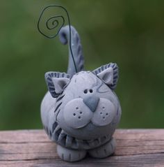 a gray ceramic cat figurine sitting on top of a wooden table