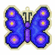 a cross stitch butterfly with purple and yellow dots on it's wings, sitting on a white background