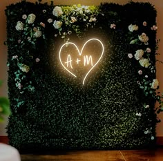 a white cake sitting on top of a table next to a green wall with a heart