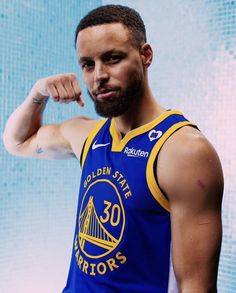 a man in a golden state warriors jersey flexing his fist and looking at the camera