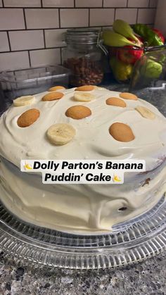 a cake sitting on top of a counter covered in white frosting and lots of cookies