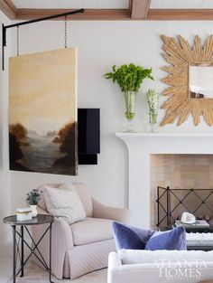 a living room filled with furniture and a fire place under a painting on the wall