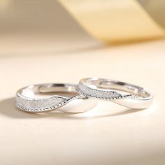 two wedding rings sitting on top of a table