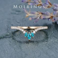 an image of a ring with blue stones and diamonds on it, sitting next to lavender flowers