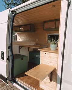 the interior of a camper van with its door open and storage boxes on the side