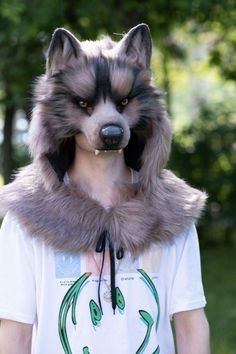 a person wearing a wolf mask with trees in the background