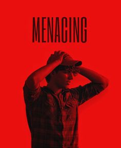 a man in a red shirt and hat holding his hands to his head with the words menacing on it