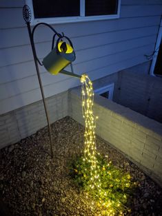 a watering can is lit up in the yard