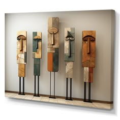 four wooden sculptures are lined up against a wall