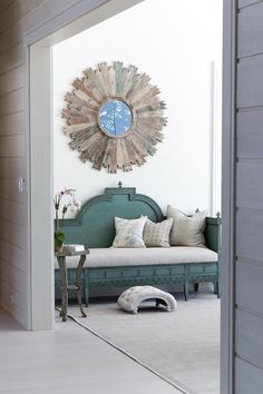 a dog laying on the floor in front of a couch with a clock above it