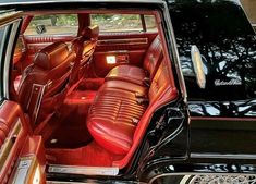 the interior of a black car with red leather seats