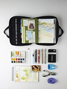 the contents of a travel kit laid out on a white surface with scissors, pens and markers