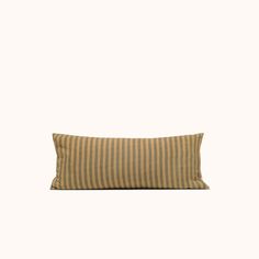 a striped pillow sitting on top of a white wall