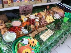 a table filled with lots of food on top of a green cloth covered tablecloth