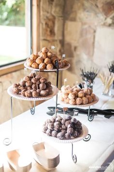 three tiered trays filled with different types of donuts on top of a table