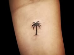 a small palm tree tattoo on the arm