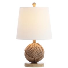 a rope ball lamp on a wooden base with a white linen lampshade behind it