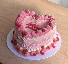 a pink heart shaped cake on a table