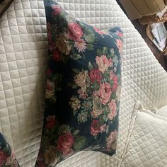 a floral pillow on top of a bed