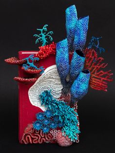 a red box with blue corals and seaweed in it on a black background