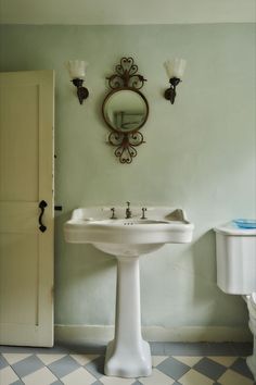 a white pedestal sink sitting under a mirror