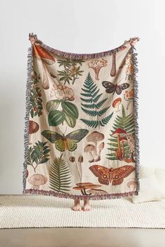 a blanket with many different types of plants and animals hanging from it's sides