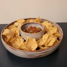 a bowl filled with chips and salsa on top of a table