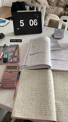 an open book sitting on top of a white table next to a calculator