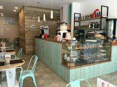 the inside of a restaurant with tables, chairs and shelves full of food on display