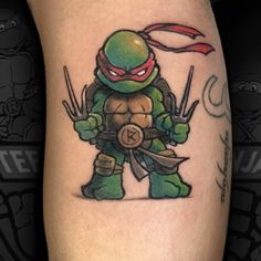 a tattoo on the leg of a man with a ninja turtle holding two swords in his hand