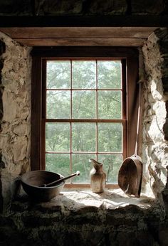 a cat sitting on a window sill next to a pan