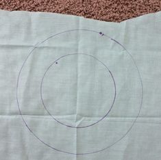 a piece of paper with a blue circle drawn in it on top of carpeted floor