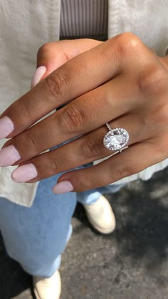 a woman's hand with a ring on her finger and a diamond in the middle