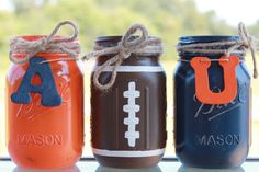 three mason jars decorated with footballs and the letter a