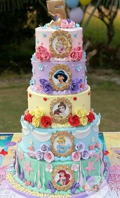 there is a multi layer cake with princesses on it