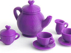 a purple tea set with cups and saucers