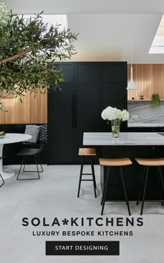 an open kitchen with black cabinets and white counter tops is seen in this image from the dining room