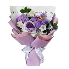 a bouquet of crocheted flowers is wrapped in purple and white ribbon with the word congratulations written on it