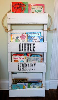 a book shelf made out of old pallets with books on top and the words little library written on it