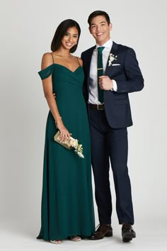 a man and woman in formal wear posing for a photo together, dressed in dark green