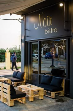 the outside of a restaurant with wooden benches and tables