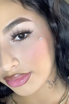 a close up of a woman with tattoos on her face and eyeliners, looking at the camera