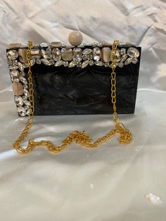 - Tich lock closure  - Golden chain inside - Removable sling chain This clutch can be worn as a shoulder bag with the sling chain or can simply be carried in hand.It is spacious enough to carry mobile phones, lipsticks, Keys and other small accessories.It comes in dust cover placed in a corrugated box. Elegant Clutch With Chain For Gift, Elegant Clutch With Chain Detail For Gifts, Elegant Clutch With Chain As A Gift, Elegant Chain Clutch, Luxury Box Bag With Chain Strap For Evening, Elegant Box Bag With Chain, Elegant Chain Evening Bag As Gift, Designer Rectangular Box Bag For Evening, Designer Square Clutch For Evening