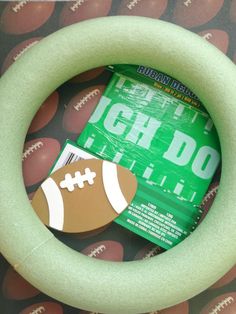 a green foam ring with a football on it and a paper tag in the middle