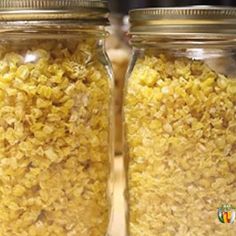 two jars filled with yellow rice sitting on top of a wooden table next to each other