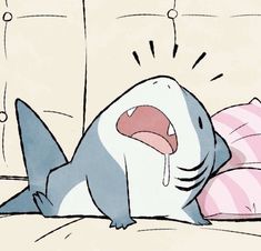 a cartoon shark with its mouth open laying on a bed