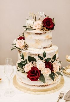 a white wedding cake with red and white flowers