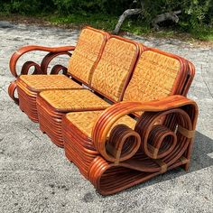 a wooden bench made out of wicker with rolled up seats on it's sides