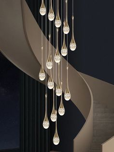 a chandelier hanging from the side of a spiral staircase in a room with black walls